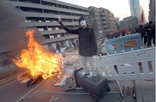 Ein Blockupy-Aktivist vor einer brennenden Barrikade in Frankfurt am Main.  Foto: dpa