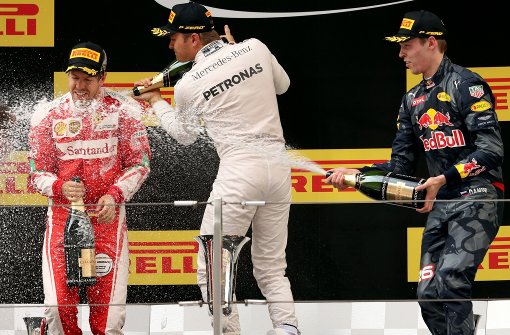 Der China-Sieger Nico Rosberg (Mitte) verteilt zur Feier des Tages großzügig den edlen Tropfen. Foto: AP