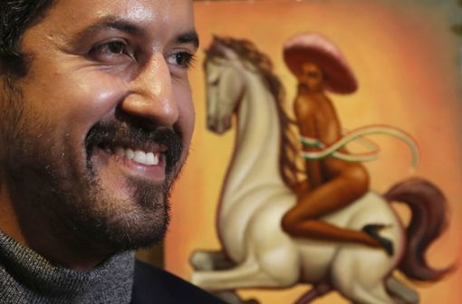 Der mexikanische Künstler Fabián Cháirez steht hier noch lachend vor seinem umstrittenen Gemälde des Volkshelden Zapata. Foto: dpa/Marco Ugarte