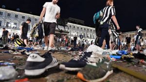 Dutzende verlorene Schuhe und Rucksäcke liegen auf der Piazza San Carlo in Turin. Foto: dpa