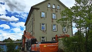 Am Dienstag bot sich dem Betrachter dieses Bild: der Abrissbagger steht bereit, aber das Alte Schulhaus ist noch kaum angetastet. Foto: Fritzsche