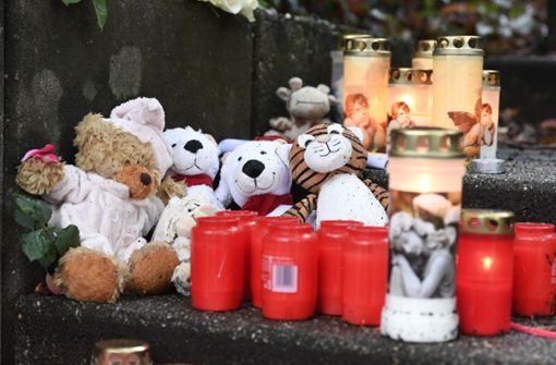 Teddybären und Kerzen haben Mitmenschen vor dem Haus niedergelegt, wo die Polizei die Kinder gefunden hat. Foto: dpa/Roberto Pfeil