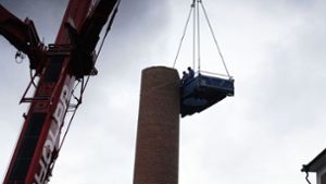Die Arbeiter stehen in luftiger Höhe in einer Art Container-Gondel, die von einem 350 Tonnen schweren Kran gehoben wird. Foto: Andreas Rosar/Fotoagentur-Stuttgart