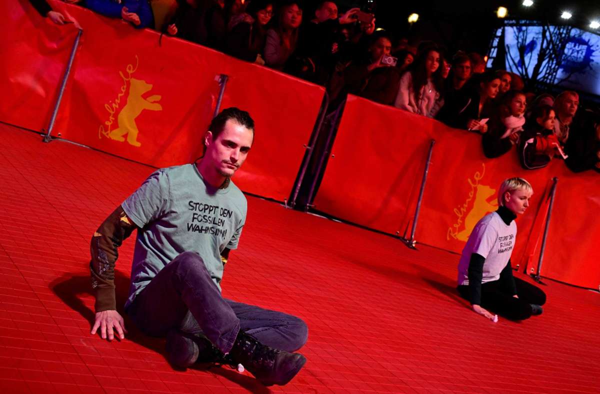 Die Aktivisten klebten sich am Rande des roten Teppichs auf dem Boden fest. Foto: AFP/JOHN MACDOUGALL