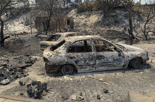 Die Waldbrände in Griechenland hinterlassen( Bild: verbrannte Autowracks stehen  auf einer Straße der griechischen Insel Rhodos) Schneisen der Verwüstung. Foto: L/fteris Damianidis/InTime News/AP/dpa