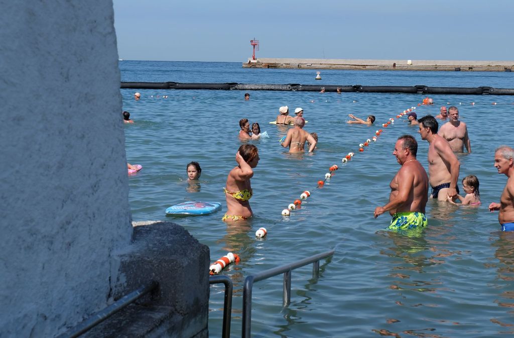 Im Wasser finden Männer und Frauen in Triest durch ein Seil getrennt wieder zusammen – am Strand liegen sie getrennt.