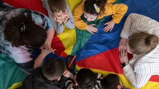 Eine Erzieherin samt Schützlingen in einem Kindergarten. Foto: dpa/Marijan Murat