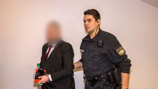 Der Angeklagte wurde von einem Beamten in den Gerichtssaal gebracht Foto: dpa/Heiko Becker