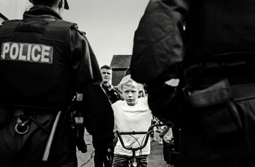 Düstere Zukunft? Der Junge Brendan blickt von seinem Fahrrad aus auf Polizisten in der Trinity Street Foto: Toby Binder