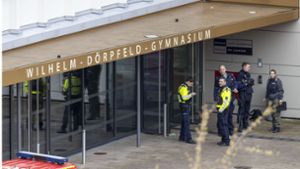 Polizeibeamte stehen vor dem Wilhelm-Dörpfeld-Gymnasium in Wuppertal. Hier sind am 22. Februar  mehrere Schüler schwer verletzt worden. Foto: dpa/Christoph Reichwein