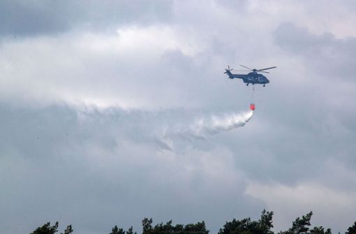 Ein Hubschrauber der Bundespolizei wirft Löschwasser zum Eindämmen des Feuers auf dem ehemaligen Truppenübungsplatz bei Lübtheen in Mecklenburg-Vorpommern ab. Foto: dpa