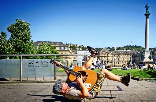 Rücklings mit zappelnden Beinen liegt Straßenmusiker Kieran Hilbert  bei „Highway to Hell“ auf dem Schlossplatz-Boden. Foto: Lichtgut/Achim ZweygarthLichtgut/Achim Zweygarth
