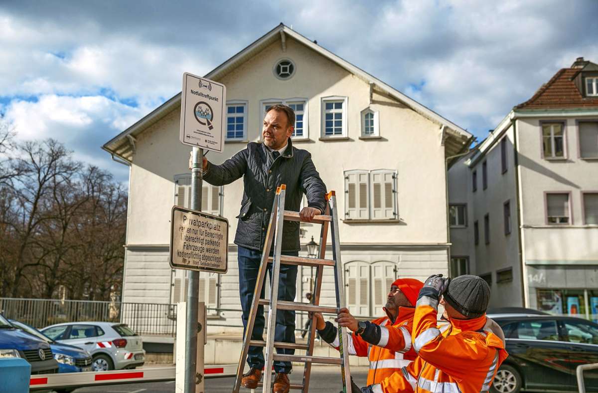 Der Erste Bürgermeister Ingo Rust befestigt das Schild für den neuen Notfalltreffpunkt in der Ritterstraße in Esslingen. Foto: Roberto Bulgrin
