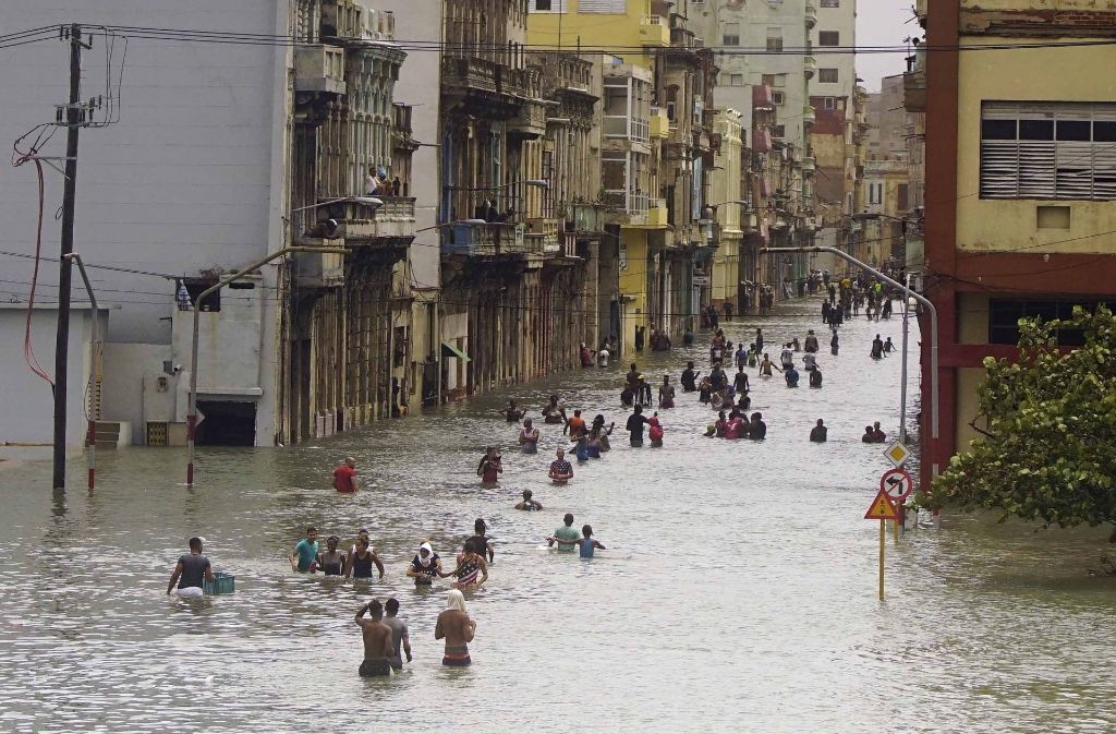In Kubas Hauptstadt Havanna waten die Menschen durch überflutete Straßen.