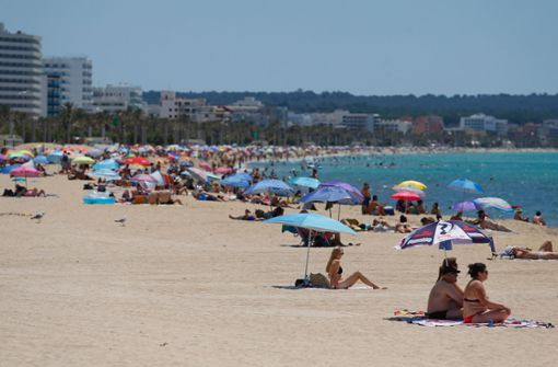 Spanien, Palma: Menschen sonnen sich am Strand El Arenal. Nach wochenlanger Corona-Pause können Urlauber wieder auf die Insel reisen. Foto: dpa/Clara Margais