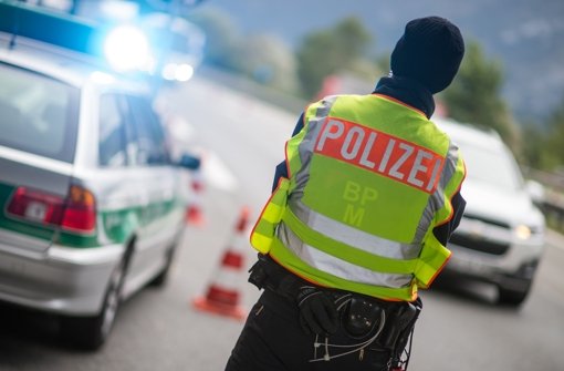 Ein Polizeibeamter macht Stichproben an der Anschlussstelle Bad Reichenhall der Autobahn A8 von Salzburg nach München (Bayern) bei Fahrzeuge, die aus Österreich kommen. (Archivfoto) Foto: dpa