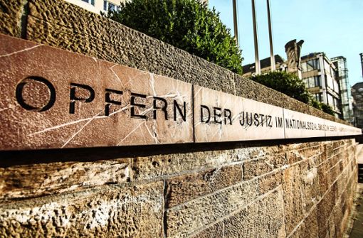 Die  Inschrift an der Mauer aus rotem Sandstein gedenkt der Opfer – aber unzulänglich, so die Kritik. Foto: Lg/Rettig,Kovalenko