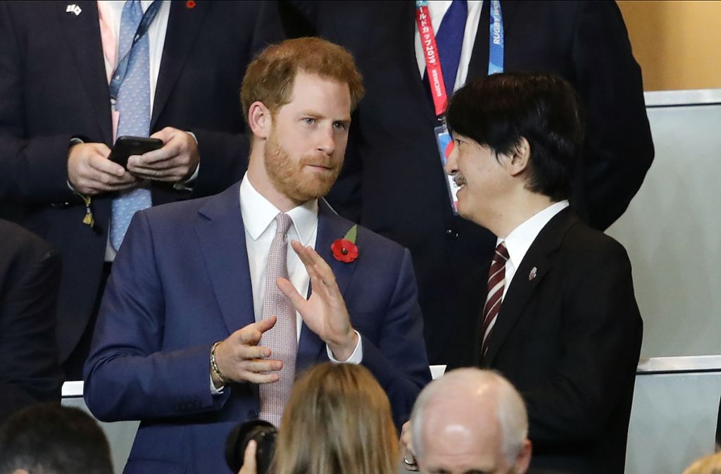 Auf der Tribüne sitzt Prinz Harry neben Japans Kronprinz Akishino.