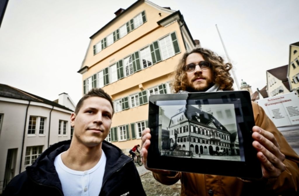 Sven Straubinger(links) und Benjamin Schaufler vor dem Nürtinger Rathaus, auf dem iPad zeigen sie  eine alte Ansicht des Gebäudes.  Foto: Leif Piechowski Foto:  