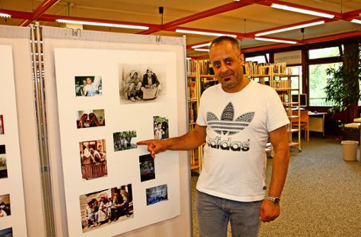 Mosab Abdul Whab zeigt bei der Ausstellung in der Stadtteilbücherei   Fotos aus  seinem Heimatort bei Homs. Foto: Georg Friedel