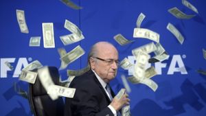 Archivfoto: Fifa-Präsident Joseph ‚Sepp’ Blatter wird auf einer Pressekonderenz nach der außerordentlichen Sitzung des FIA-Exekutivkomitees im Juli 2015 in Zürich  vom britischen Comedian Simon Brodkin mit Gelscheinen beworfen. Foto: dpa