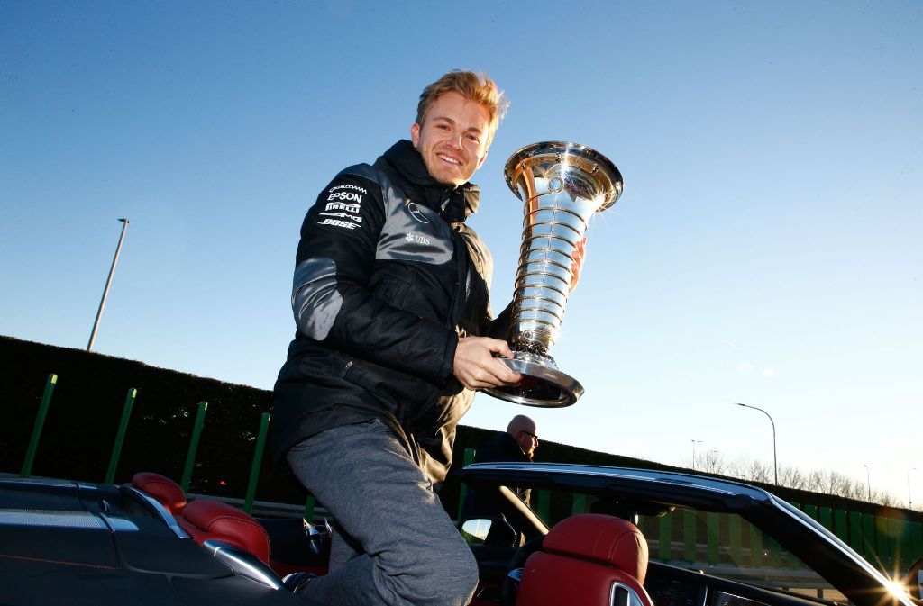 Da ist der Pott: Nico Rosberg zeigt ihn noch einmal im Mercedes-Werk in Sindelfingen. Foto: Mercedes