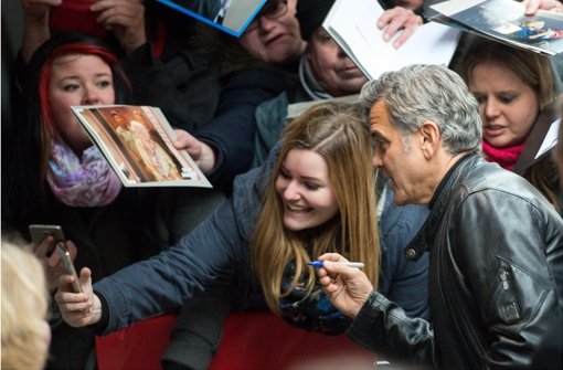 Das mit dem Unterschreiben wird schwierig, aber ein Selfie mit George Clooney ist ja auch nicht schlecht. Bilder vom Trubel vor der Berlinale-Premiere von Clooneys Film „Hail Caesar“ zeigt die folgende Fotostrecke. Foto: dpa