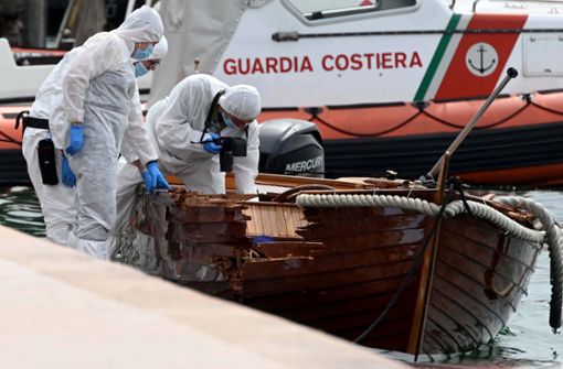 Italienische Forensiker begutachten den Schaden an einem Boot. Foto: dpa/Gabriele Strada