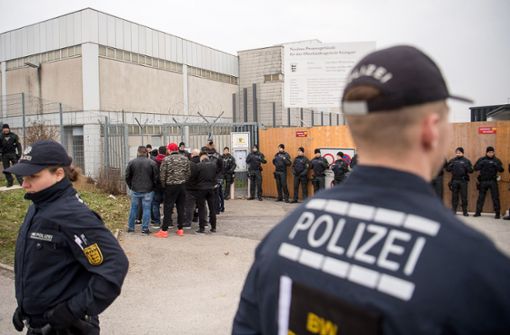 Besucher und Polizisten stehen am Eingang des Gerichtsgebäudes in Stuttgart-Stammheim, wo derzeit der Prozess gegen Mitglieder  der türkisch-nationalistischen Straßengang «Osmanen Germania BC» stattfindet. Foto: dpa