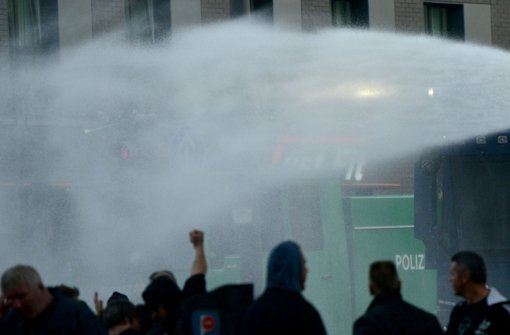 Nachdem bei einer Demo von Hooligans in Köln Flaschen, Steine und Feuerwerkskörper auf die Beamten geworfen worden seien, setzte die Polizei Wasserwerfer ein. Foto: dpa