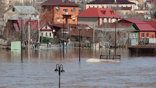 Anwohner stehen an einer Absperrung und beobachten ein überschwemmtes Gebiet im russischen Orenburg. Foto: Uncredited/AP/dpa