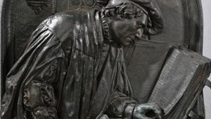 Luther und  die Sprache: Ein Relief mit der Darstellung Martin Luthers als Bibelübersetzer auf der Wartburg Es gehört zum Sockel der Luther Plastik in Eisleben. Foto: dpa