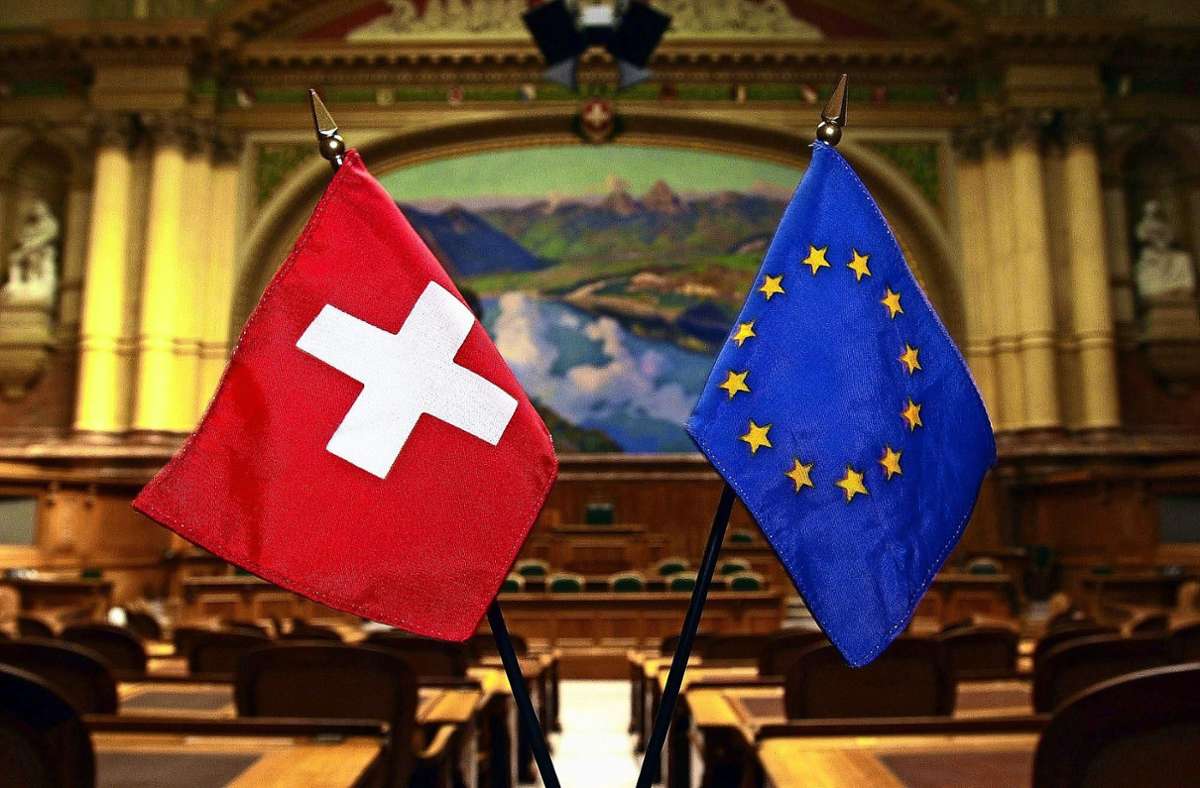 Fähnchen der EU und der Schweiz im Nationalratssaal in Bern. Foto: dpa/Michael Stahl
