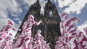 Hunderte Kinderpuppen zeigen auf den  Kölner Dom