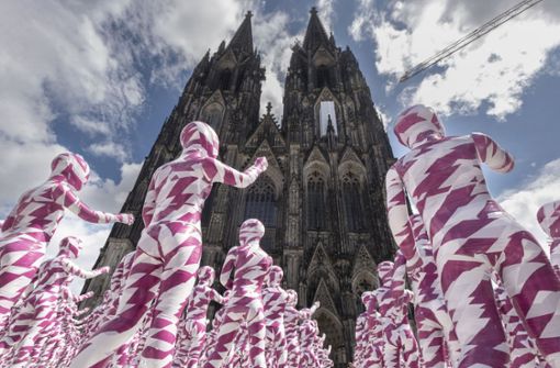 Die Kinderpuppen zeigen auf das Gotteshaus in Köln. Foto: epd/Guido Schiefer