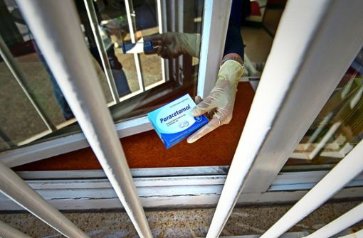 In der Charlotten-Apotheke am Olgaeck in Stuttgart reicht eine Mitarbeiterin eine Packung Paracetamol durchs Verkaufsfenster. Die Ladentür bleibt in diesen Tagen geschlossen. Foto: Lichtgut/Leif Piechowski