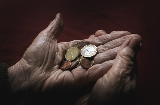 Eine ältere Frau hält Euromünzen in der Hand. Die Zahl überschuldeter Senioren wächst dramatisch – im Gleichklang mit der Altersarmut in Deutschland. Foto: dpa
