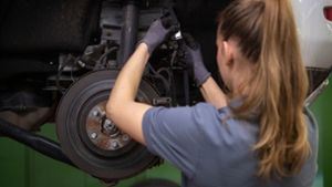 Eine Kfz-Mechanikerin wechselt in einer Werkstatt die Bremsscheibe eines Range Rover Evoque. Die berufliche Arbeitszeit von Frauen ist in der Corona-Krise im Schnitt stärker gesunken als die von Männern. Foto: Marijan Murat