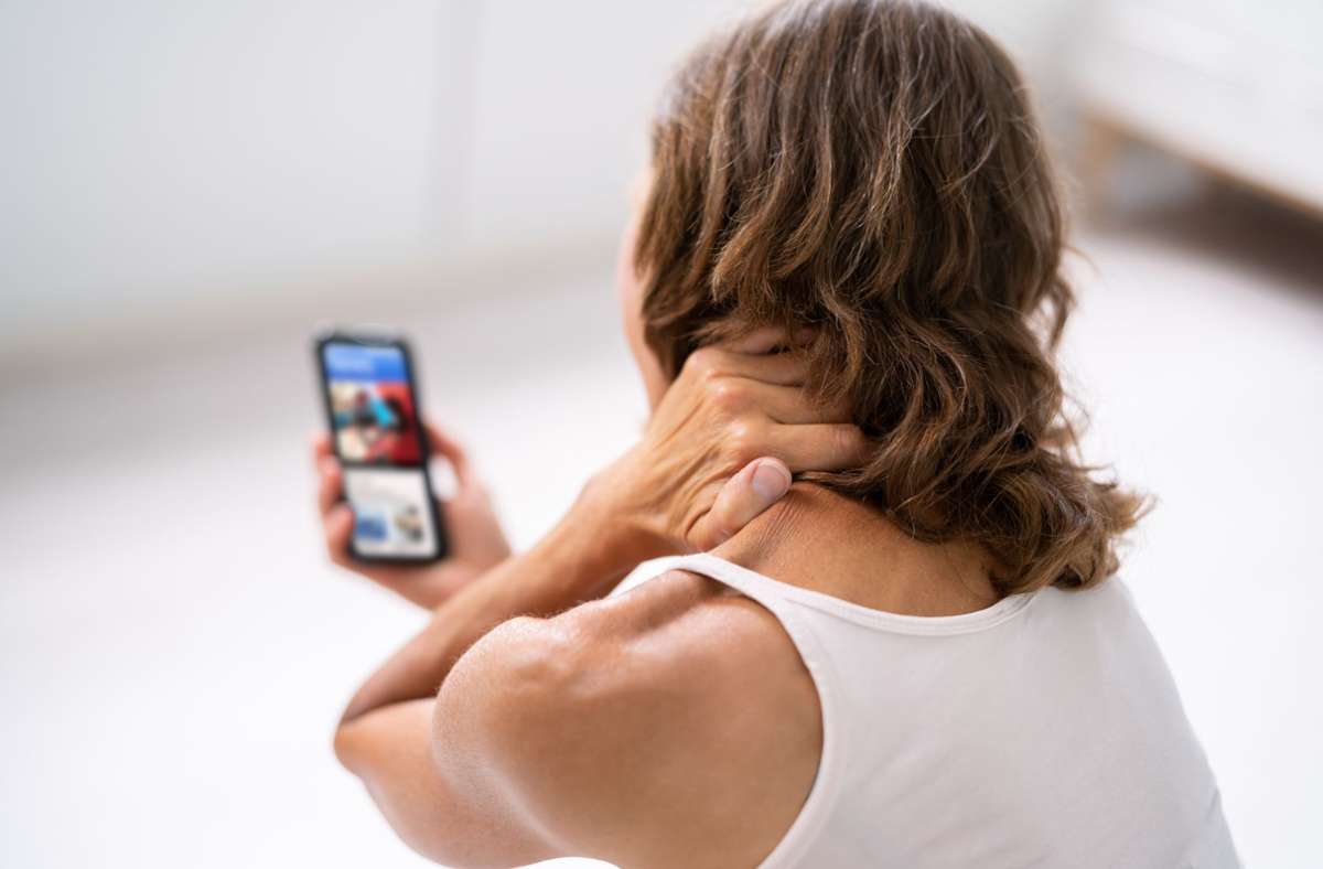 Zu viel in  falscher Haltung aufs  Smartphone schauen, kann Nackenschmerzen auslösen. Foto: Andrey Popov
