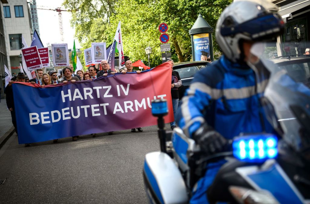 28.04.2018, Baden-Württemberg, Karlsruhe: Demonstranten tragen ein Banner mit der Aufschrift „Hartz IV bedeutet Armut“ Foto: picture alliance / Sina Schuldt//Sina Schuldt