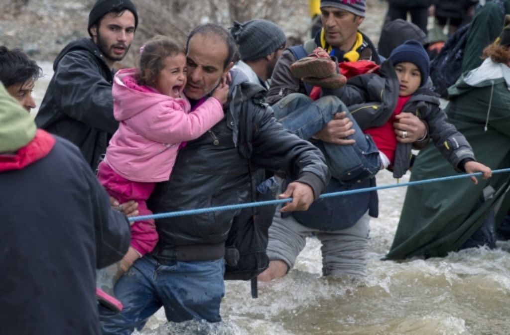 Hunderte Flüchtlinge versuchen am Montag, aus dem Lager bei Idomeni Richtung Mazedonien durchzudringen. Dabei waten sie durch einen Fluss. Weitere Bilder vom Montag zeigt die folgende Fotostrecke. Foto: AP