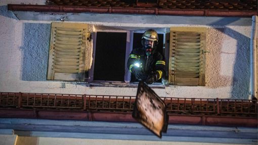 Ein Feuerwehrmann lüftet das verrauchte Dachgeschoss. Foto: 7aktuell.de/Simon Adomat