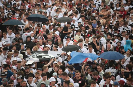 Die Fans der Eintracht stehen bei der Fanparty im Regen. Foto: dpa/Sebastian Gollnow