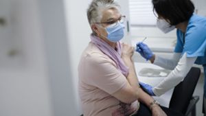 Eine Assistentin impft eine Patientin in einer Arztpraxis gegen Corona. Foto: epd/Tim Wegner