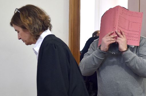 Der ehemalige Pfleger Niels H. versteckt sich bei einem Gerichtstermin in Oldenburg hinter einer Mappe, links im Bild seiner Verteidigerin Ulrike Baumann. Foto: DPA