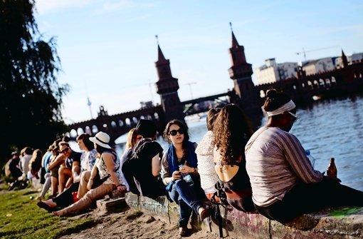 Touristen genießen den Sonnenschein am Spreeufer  Foto: dpa