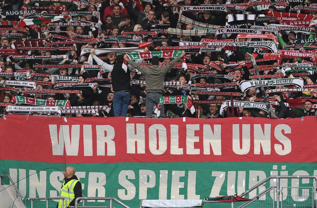 Augsburger Fans halten ein Transparent mit der Aufschrift „Wir holen uns unser Spiel zurück“.
