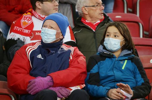 Zuschauer tragen Mundschutz auf den Rängen der Mercedes-Benz-Arena. Foto: Baumann