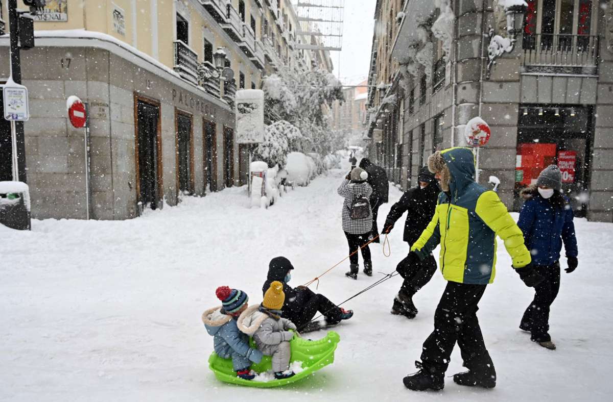 Neuschnee macht’s möglich: Diese Kinder in Madrid erleben eine völlig neue Fortbewegungsart. Foto: AFP/Gabriel Bouys