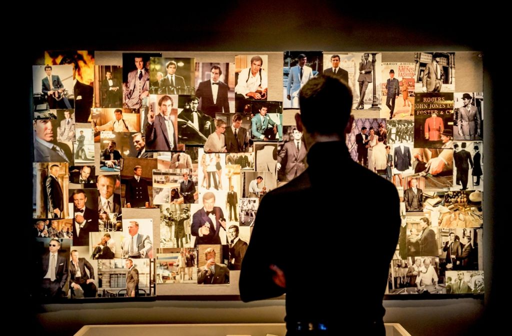 Von Sean Connery bis Daniel Craig: Ein Besucher betrachtet eine Wand mit Aufnahmen der  verschiedenen Bond-Darsteller. Foto: dpa